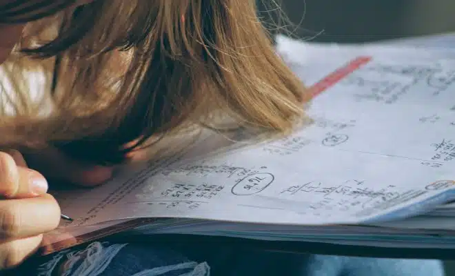 woman in blue denim jacket holding white paper