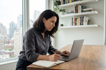 Femme concentrée travaillant sur son ordinateur dans un appartement moderne
