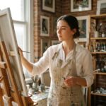 Étudiante en formation artistique privée travaillant sur une toile dans un atelier de peinture chaleureux et intimiste