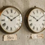Deux horloges murales analogiques côte à côte indiquant l'heure de Paris et de La Réunion