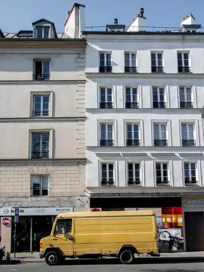 yellow bus in front of white concrete building